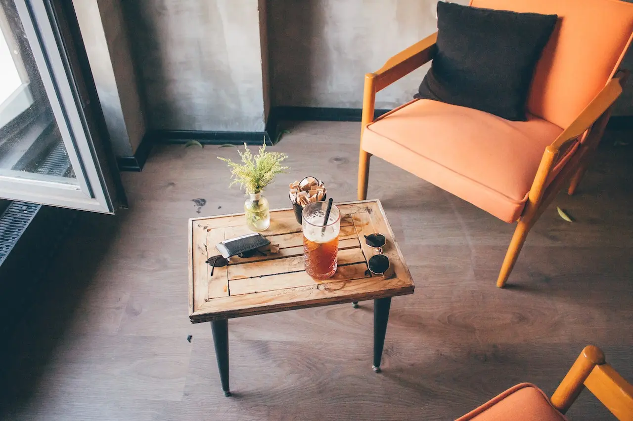 میز عسلی که در جلوی پنجره قرار دارد و صندلی های چوبی در کنار آن قرار دارند