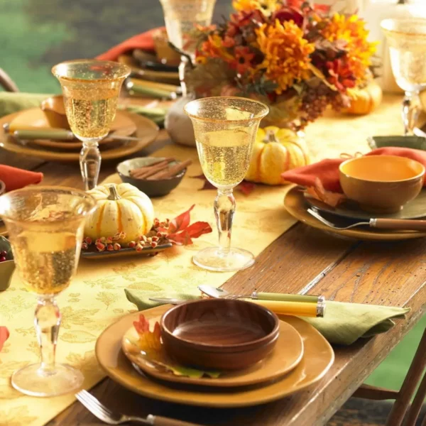 میز ناهار خوری که افتاب در آن تابیده است و بقشاب لیوان و قاشق ها نیز در روی میز چیده شده است