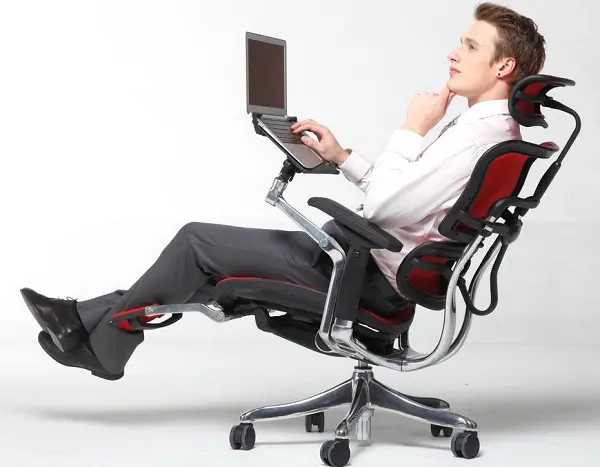 صندلی کارمندی که فردی روی آن نشسته و پایه لپ تاپ دارد