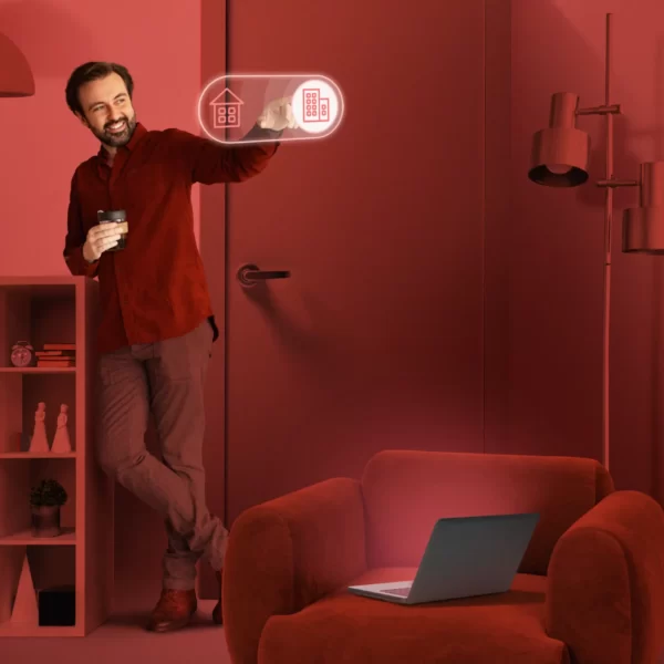 اتاقی که تم قرمز دارد و فردی که نیز در ان قرار دارد لباس قرمز پوشیده است و درحال کار با تکنولوژی خانه میباشد