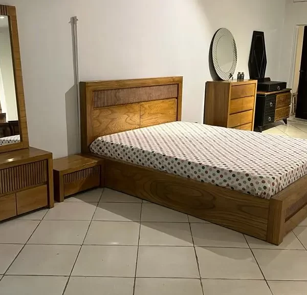 نمایشگاهی که ست اتاق خوابی چوبی که شامل تخت دو نفره و آیینه و کمد میشود قرار دارد