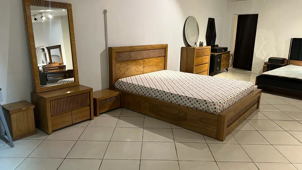 نمایشگاهی که ست اتاق خوابی چوبی که شامل تخت دو نفره و آیینه و کمد میشود قرار دارد 